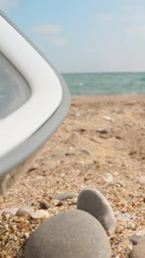 Scuba diving mask, on the seashore, boats floating in the background. Dolly, Vertical, Social Media.