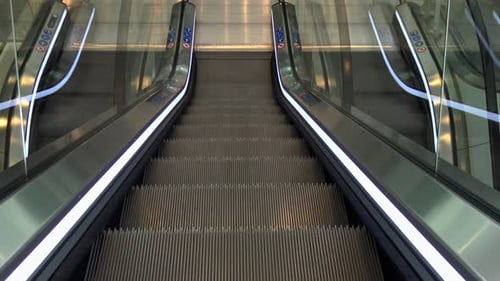 An escalator going down and arriving at the bottom.