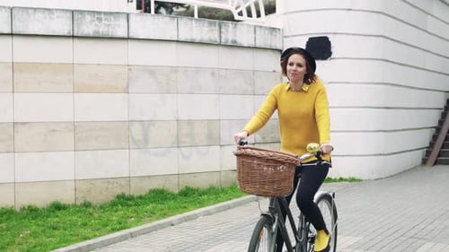 Young Woman Riding Bicycle in Sunny Spring Town