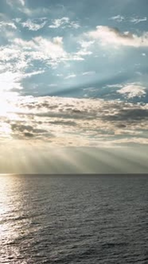 Vidéo verticale de Cloudscape Symphony montrant un coucher de soleil magique projetant des teintes dorées sur la mer