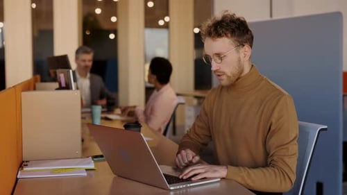 Successful Young Businessman Getting Good News on Laptop at Office