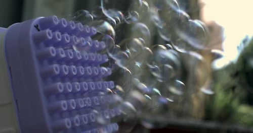 Close-up of a bubble machine releasing bubbles in slow motion at 800 fps, showing detailed nozzles
