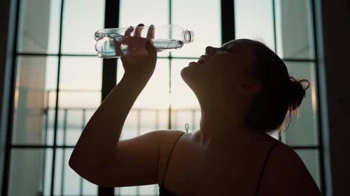 Woman Drinks Water Refreshing After Exercise Indoors