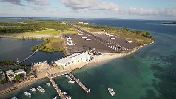 Small plane takes off from Los Roques airport on a sunny day with boats ...