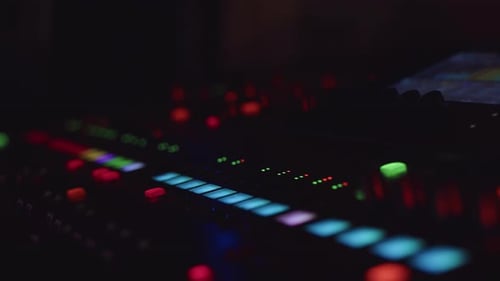 Closeup of the Sound Mixing Console Board with a Lot of Glowing Buttons and Scales During the Live
