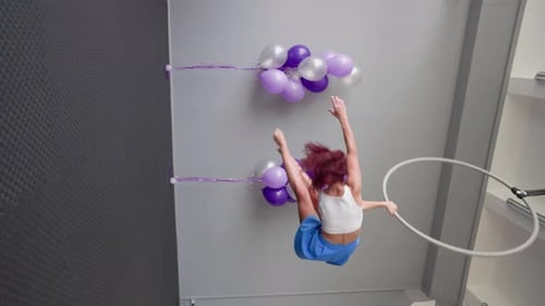 Graceful Woman Aerialist Performs a Trick on Aerial Hoop Spinning in the Splits