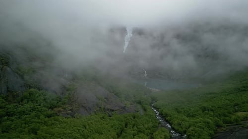 Drone shot of Briksdalsbreen in Norway. The low-hanging clouds reveal the glacier arm.