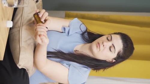 Woman Taking Medication with Water Indoors