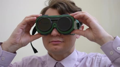 Front View Headshot of Confident Man Looking at Camera Putting on Glasses for Color Blindness Test