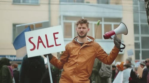 Man Holds Sale Sign in a Crowd