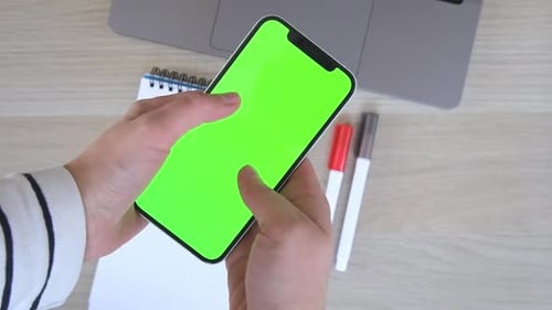 Hands Using Smartphone with Green Screen Display