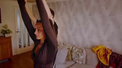 Attractive young couple doing yoga exercises at home