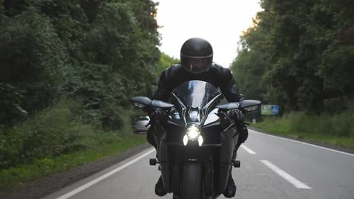 Biker Rides on Modern Motorbike at Woodland Rural Route Motorcyclist Travel at Motorcycle on Forest