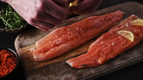 Raw Salmon Preparation with Lemon on Wood Board