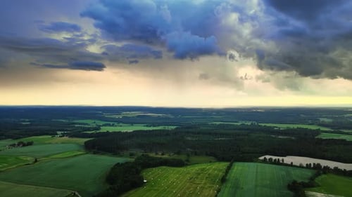 Rain clouds over the green fields of the outskirts of Hjo, Sweden -Aerial