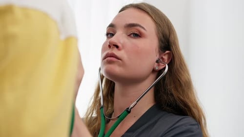 Close Up in a Modern Clinic in a Small Therapist s Office a Young Girl Doctor with a Stethoscope