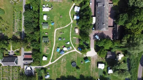 Birdseye view of vehicle towing caravan entering a camping site