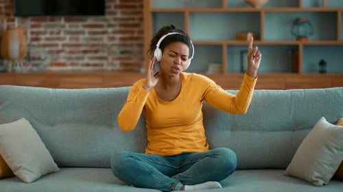 Woman Enjoying Music with Headphones on Sofa