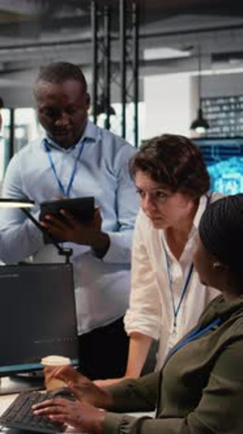 Colleagues Work Together at Computer in Office