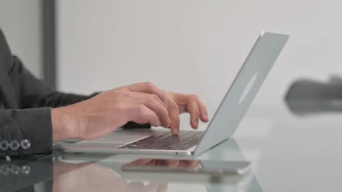 Side View of Businessman Typing on Laptop