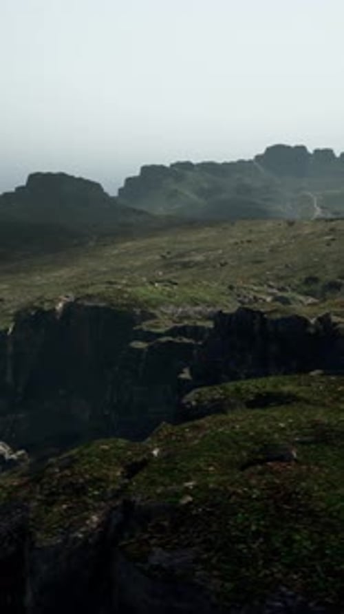 A View of a Rocky Mountain with a Foggy Sky in the Background