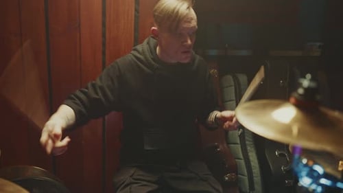 Drummer Performs Intense Rhythm in Small Music Venue at Night