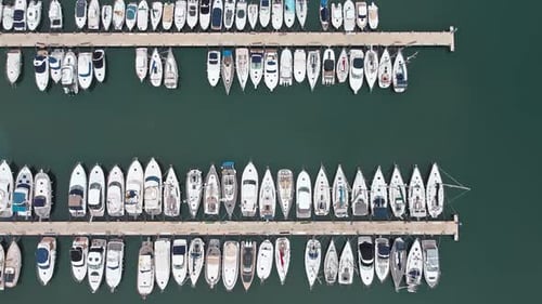 Sea and port from drone aerial shot. Zenith bird eye view of blue water with many boats on the dock.