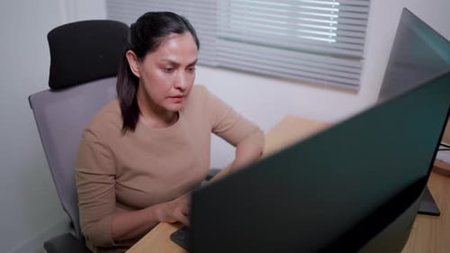 Enthusiastic woman working on desktop computer Female experts creating innovative software App devel