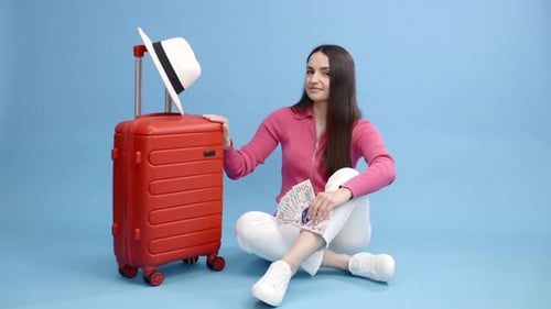 Woman with Suitcase and Money Preparing for Vacation