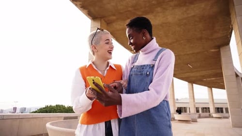 Two Women Friends Looking at Smartphone Outdoors