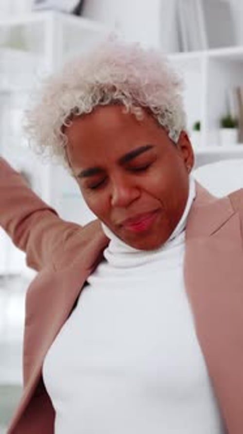 Confident Professional Woman Stretches and Celebrates in Bright Modern Office