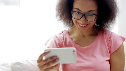Smiling Woman Takes Selfie Indoors with Mobile Phone