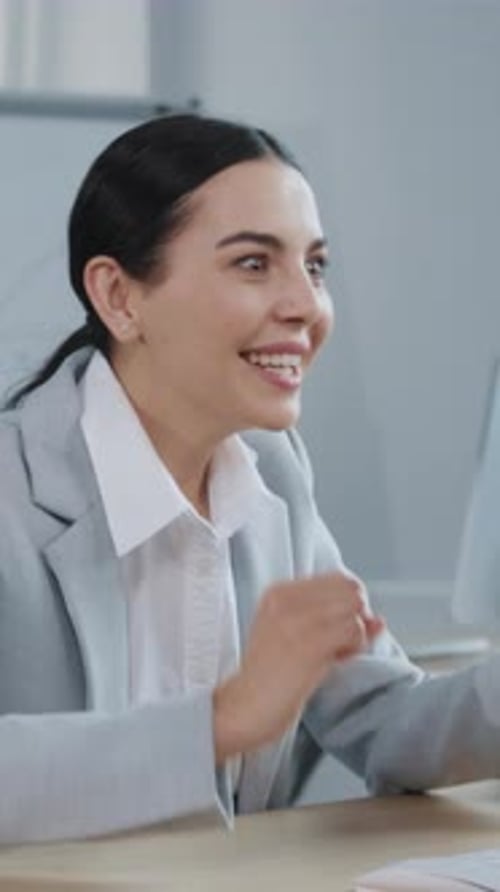 A Professional Woman is Engaged in Her Work at a Desk Within a Modern Office Environment