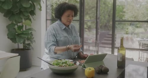 Woman Prepares Colorful Salad in Kitchen