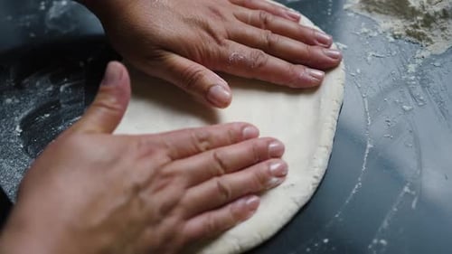 The chef works with his hands on the dough