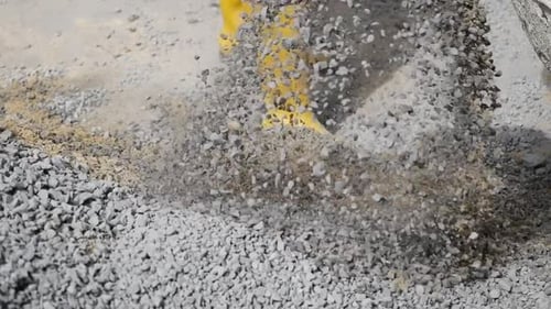 Worker Preparing Gravel for Construction in Urban Area