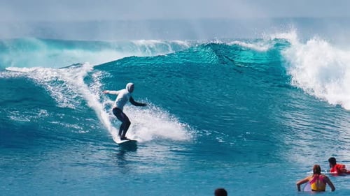 Young man surfs the wave at Sultans surf spot in Maldives. Amateur beginner surfer rides the wave