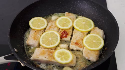 Fish Filets with Lemon Slices Cooking in Pan