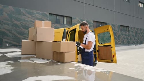 Delivery Driver Loading Cardboard Boxes from Yellow Van