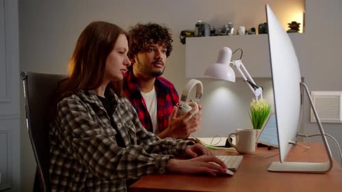 Man and Woman Working Together at Computer Indoors