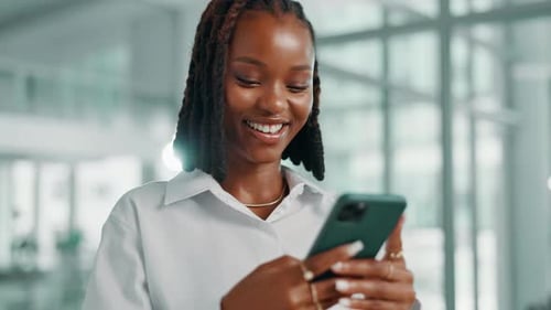 Woman Smiling at Mobile Device in an Office