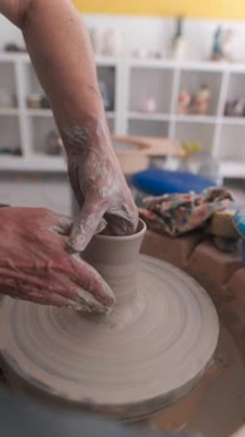 Potter shaping clay on a pottery wheel
