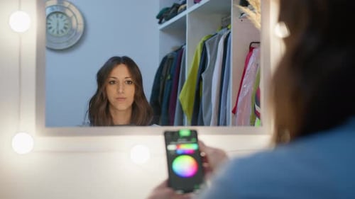 Woman Using Smartphone to Control Vanity Mirror Lights