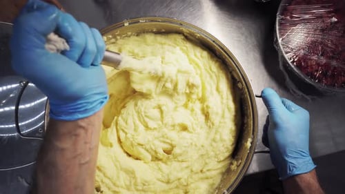 Mashing Potatoes in Commercial Kitchen Preparation Top Down View