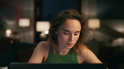Woman in Green Tank Top working on Laptop