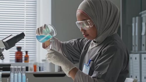 Female Scientist Pouring Liquid in Bright Laboratory