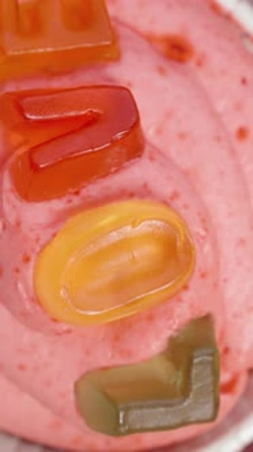 Top view of colorful and unique cupcakes with the word "Love" written and heart-shaped sprinkles.