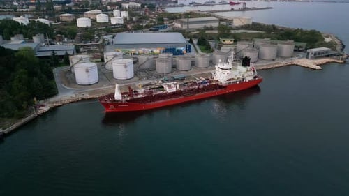 Tanker Ship Refueling at an Oil Terminal with Storage Silo's in the Port Aerial View