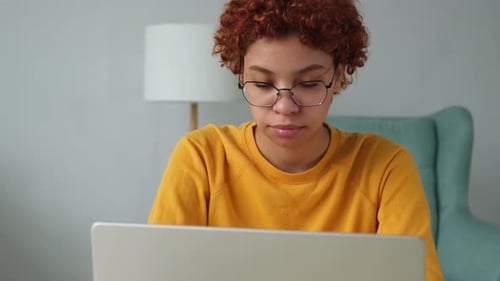 African American Girl Using Laptop at Home Office Looking at Screen Typing Chatting Reading Writing