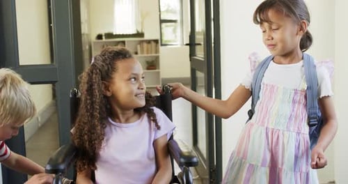 Diverse kids at doorway seated girl smiling as backpack girl heading to school touching wheelchair